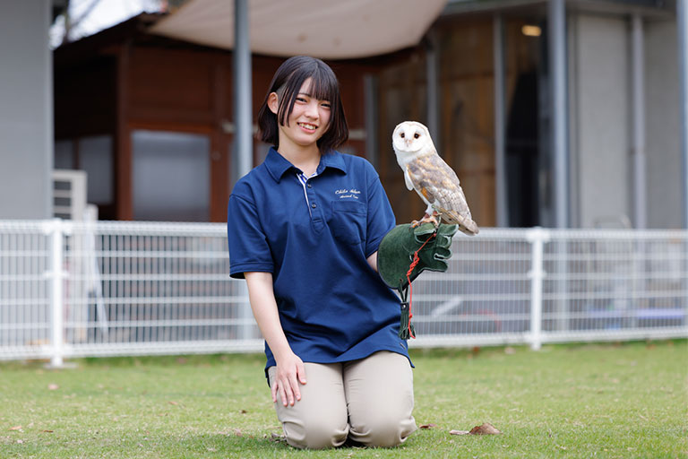 専門学校ちば愛犬動物フラワー学園 メンフクロウを手に乗せた女子生徒の写真